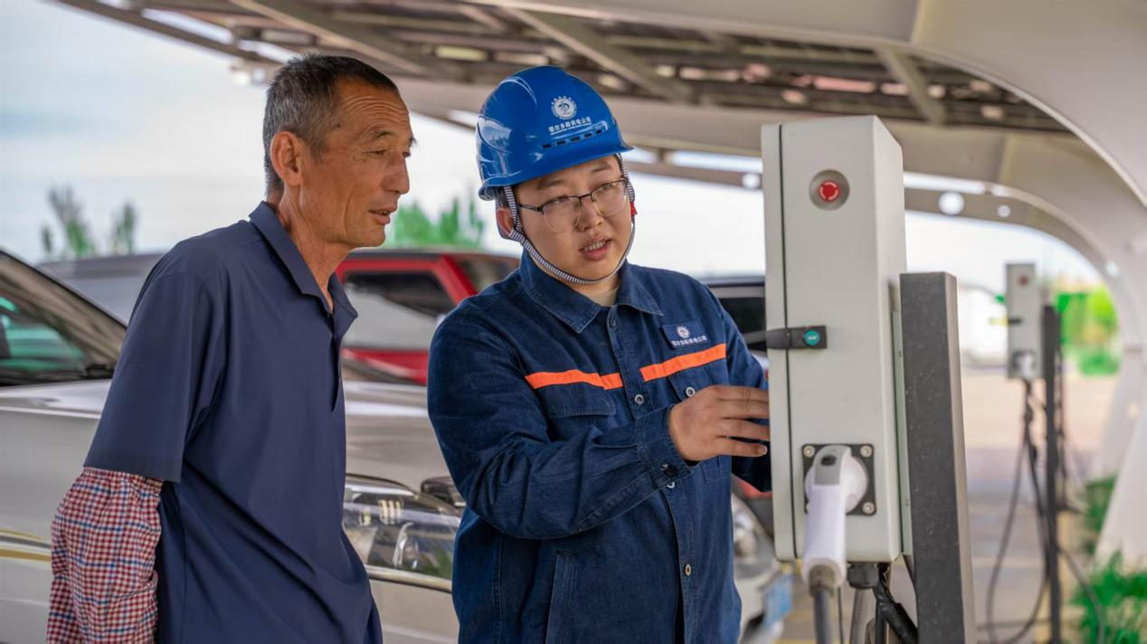 供电公司工作人员与村民交流充电事项。受访者供图