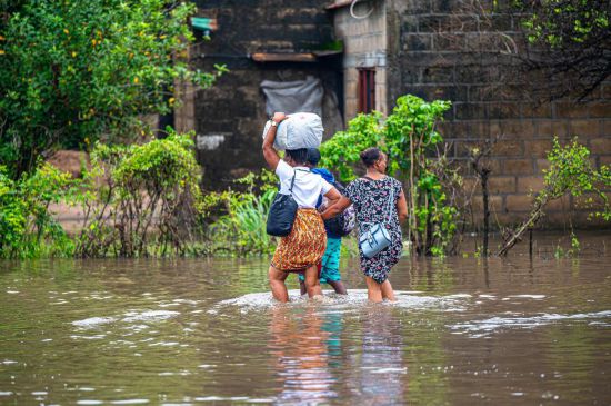 1月12日,在莫桑比克马普托省马托拉市,居民涉水通过强降雨后的积水路段。新华社发(门德斯·蒙德拉内摄)