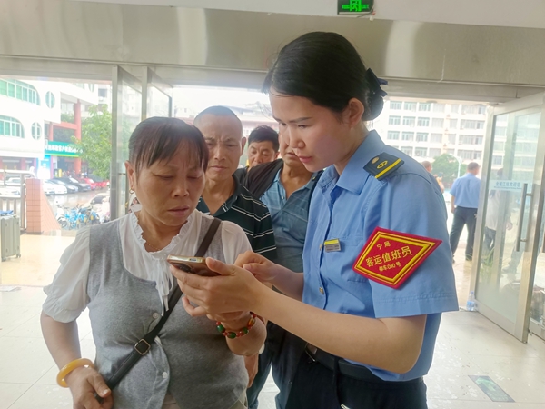 金城江站客运值班员为旅客解答问讯。覃晓平摄